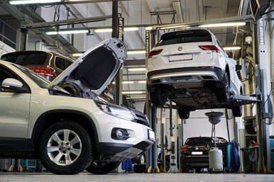 A wide shot of cars inside an auto repair shop.