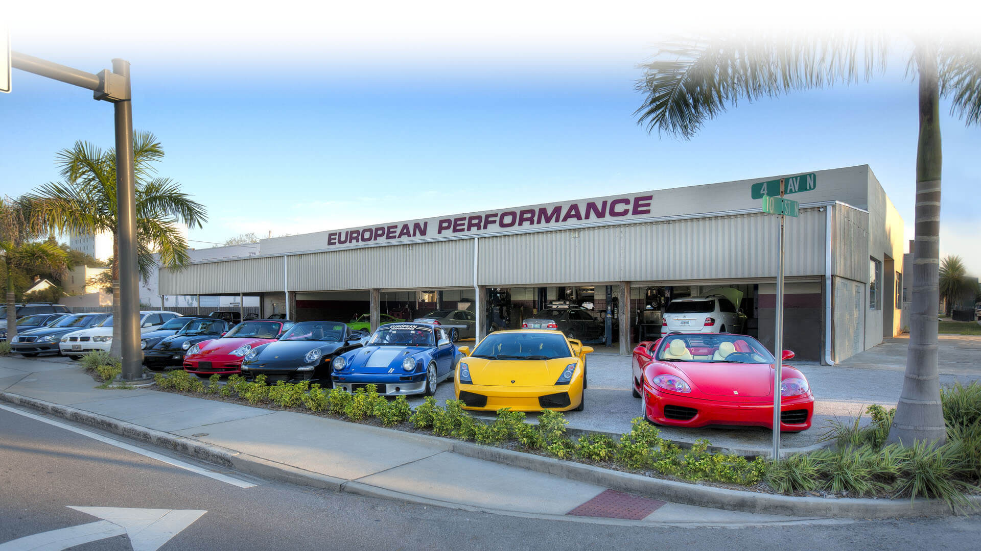 A wide shot of the European Performance front store with different car brands parked on the parking lot.